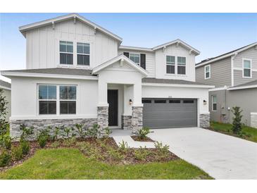 Two-story house with gray garage door and stone accents at 2918 Sharp Rd, Kissimmee, FL 34744