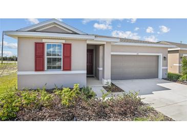 Charming home with a two-car garage, featuring a well-manicured lawn and landscaping at 636 Hennepin Loop, Lake Wales, FL 33898