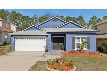 Charming home boasts a well-manicured lawn and a welcoming entrance with a lovely garden bed at 1404 Longville Cir, Tavares, FL 32778