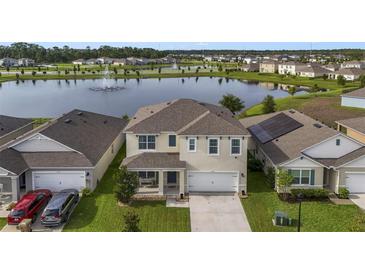 Two-story house with solar panels, lake view, and manicured lawn at 6718 Grace Hammock Rd, Harmony, FL 34773