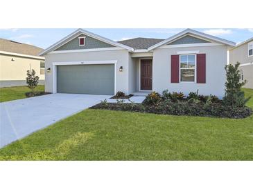 Curb appeal abounds in this charming one-story home, showcasing a well-manicured lawn and attractive facade at 907 Heirloom Dr, Haines City, FL 33844