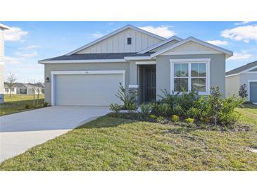 One-story house with gray siding, two-car garage, and landscaped front yard at 911 Heirloom Dr, Haines City, FL 33844