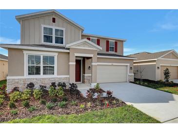 Charming two-story home with stone accents, manicured landscaping, and a two-car garage at 922 Heirloom Dr, Haines City, FL 33844