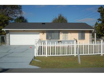 Ranch style home with white picket fence and attached garage at 267 Cranbrook Dr, Kissimmee, FL 34758