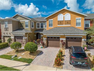Three-story townhouses with brown garages, and landscaped yards at 9532 Silver Buttonwood St, Orlando, FL 32832
