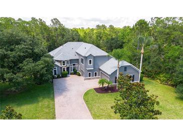Stunning two-story home with a neutral color palette, mature landscaping, and a brick driveway at 14121 Bella Ln, Orlando, FL 32832
