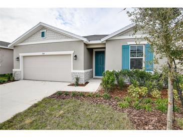 One-story house with gray siding, teal shutters, and a two-car garage at 1634 Sugarbelle Cir, Mascotte, FL 34753