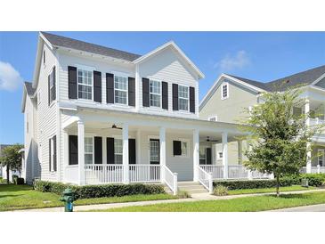 Charming two-story home features a welcoming front porch with columns and landscaped front yard at 1862 Beach Ridge Rd, Celebration, FL 34747