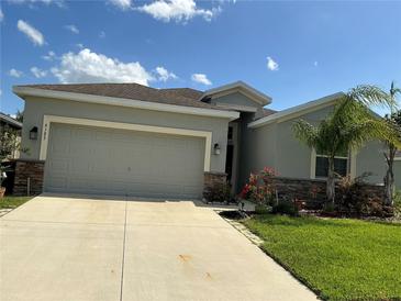 Charming home featuring a spacious two-car garage and well-maintained landscaping with a vibrant green lawn at 4183 Cortland Dr, Davenport, FL 33837