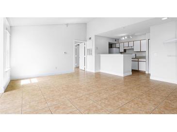 Bright living room featuring tile floors, neutral walls and access to a modern kitchen at 2217 Grand Cayman Ct # 1233, Kissimmee, FL 34741