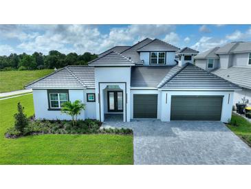 Two-story home with gray roof and white exterior, two-car garage, and landscaped lawn at 107 Hampton Loop, Davenport, FL 33837