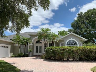Charming home featuring a beautiful front yard, complemented by well-maintained landscaping and double door entrance at 14421 Hatchee Ct, Orlando, FL 32837