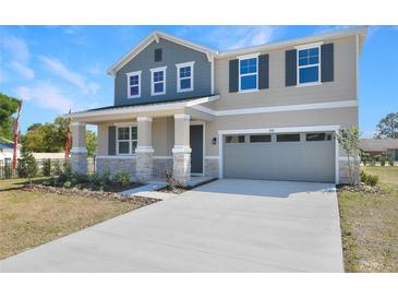 Charming two-story home featuring a two-car garage, a welcoming front porch, and eye-catching architectural details at 500 Summit River Dr, Apopka, FL 32712