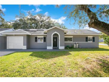 Charming single-story home with a well-maintained lawn, arched entryway, and attached garage at 3000 Cashmere Dr, Orlando, FL 32827