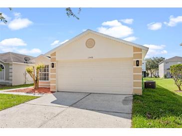 Charming one-story home featuring a two-car garage, landscaped yard, and neutral color palette at 1548 Tiverton Blvd, Winter Garden, FL 34787