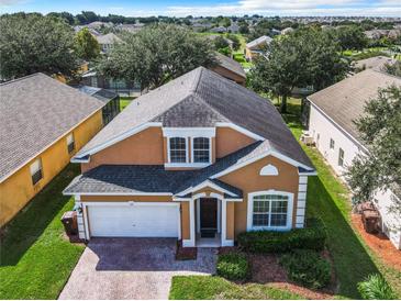 Lovely stucco two-story home with manicured lawn and a two-car garage nestled in a residential neighborhood at 133 Andalusia Loop, Davenport, FL 33837