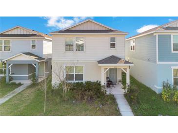 Charming two-story home with a covered front porch and well-maintained lawn at 1853 Summer Serenity Dr, Kissimmee, FL 34744