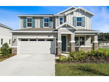 Charming two-story home featuring a two-car garage, stone accents, blue shutters and landscaped front yard at 535 Summit River Dr, Apopka, FL 32712