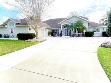 Expansive front exterior showcasing well-manicured lawn, circular drive, and mature landscaping at 62 Coquina Ridge Way, Ormond Beach, FL 32174
