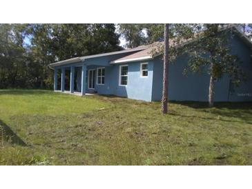 View of single-story home with blue exterior paint and lawn at 106 Sparrow Ct, Kissimmee, FL 34759