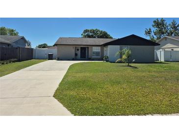 Charming single-story home featuring a well-manicured lawn and long driveway at 449 Ball Ct, Kissimmee, FL 34759