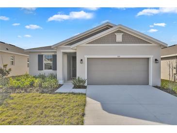 Charming single-story home featuring a two-car garage and well-maintained front yard at 814 Ballantyne Dr, Lake Wales, FL 33898