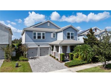 Charming two-story home with a paver driveway, an attached two-car garage, and a beautifully landscaped front yard at 11843 Imaginary Way, Orlando, FL 32832