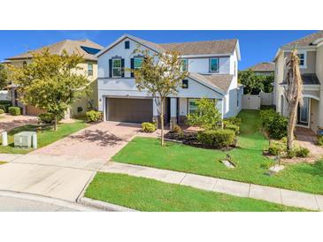 Inviting two-story home featuring a manicured lawn and a brick-paved driveway leading to a two-car garage at 5249 Villa Rosa Ave, St Cloud, FL 34771