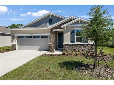 Charming single-Gathering home with stone accents, well-kept landscaping, and a two-car garage at 4064 Bannock Ave, Tavares, FL 32778