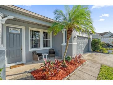 Inviting front porch with seating and a tropical palm tree at 4523 Ashtubula Ct, Orlando, FL 32818