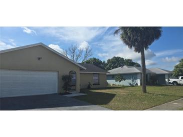 Tan house with white garage door and a palm tree in the front yard at 2118 Allspice Ave, Orlando, FL 32837