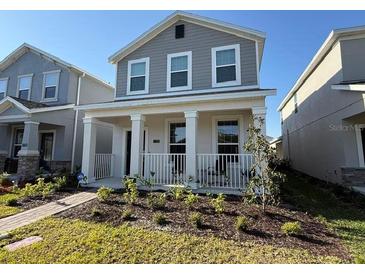 Charming two-story home featuring a welcoming front porch and well-manicured landscaping at 11720 Language Way, Orlando, FL 32832