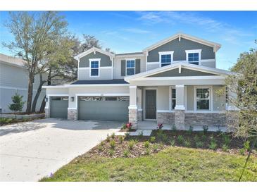 Charming two-story home boasts a three-car garage and inviting stone accents on a well-manicured front lawn at 3764 Deer Ridge Dr, Mount Dora, FL 32757