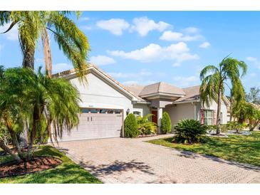 Charming home showcasing a brick driveway, lush landscaping, and a well-maintained lawn at 3643 Weatherfield Dr, Kissimmee, FL 34746
