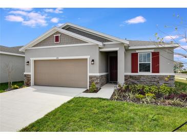 Charming single-story home with a two-car garage, stone accents, and a well-maintained lawn at 656 Hennepin Loop, Lake Wales, FL 33898