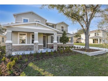 Charming two-story home featuring stone accents, a covered porch, and beautifully landscaped front yard at 3824 Deer Ridge Dr, Mount Dora, FL 32757