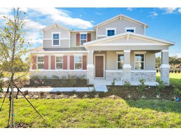 Two-story house with stone accents and red shutters at 520 Summit River Dr, Apopka, FL 32712