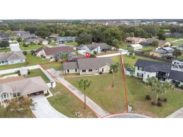 Charming single-story home featuring a well-manicured front lawn with mature palm trees and a classic driveway at 1855 Cavalier Ct, Kissimmee, FL 34744