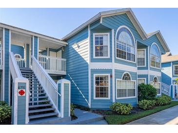 Charming two-story condo with blue siding, white trim, and well-maintained landscaping at 8716 Rain Forest Pl # D, Kissimmee, FL 34747