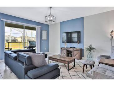 Bright living room with comfy seating and large TV at 8932 Cabot Cliffs Dr, Davenport, FL 33896