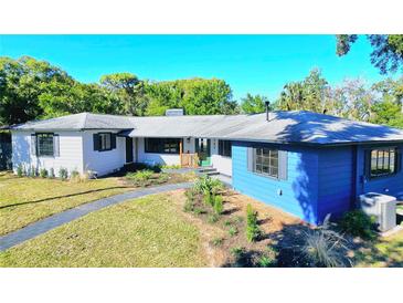 Stylish ranch home with blue exterior, landscaped yard, and walkway at 905 W 11Th Ave, Mount Dora, FL 32757