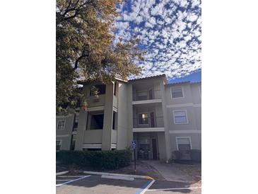 Exterior view of condo building with parking and landscaping at 3028 Parkway Blvd # 210, Kissimmee, FL 34747