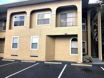 Two-story condo building featuring arched entryways, a balcony, and convenient parking spaces at 8846 Coral Palms Ct # A, Kissimmee, FL 34747