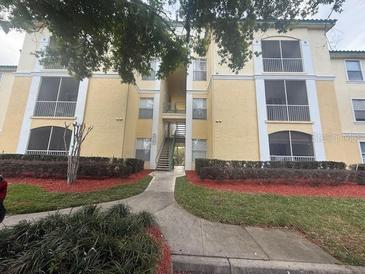 A low angle view shows the apartment building's exterior with balconies and manicured landscaping at 8910 Legacy Ct # 206, Kissimmee, FL 34747