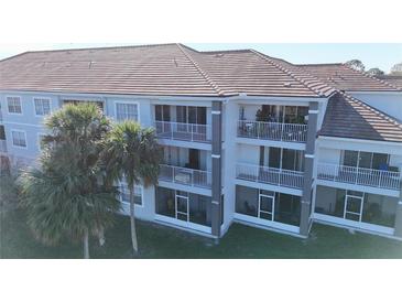 Three-story building with balconies and tile roofs in a tropical setting at 13838 Fairway Island Dr # 1432, Orlando, FL 32837