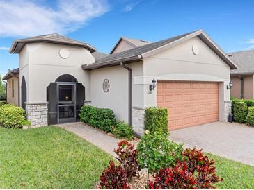 One-story home with a two-car garage and landscaped yard at 516 Pamplona Pl, Davenport, FL 33837