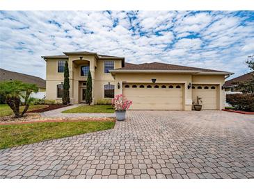 Beautiful two-story home featuring a three-car garage, landscaped yard, and a charming front entrance at 18035 Cadence St, Orlando, FL 32820