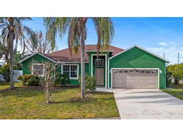 Charming one-story home with a green exterior and two-car garage at 450 Tamarind Parke Ln, Kissimmee, FL 34758