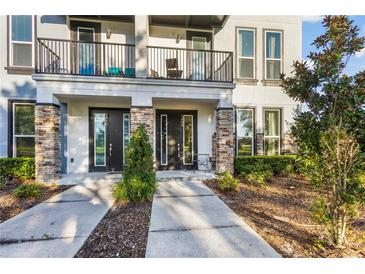 Modern townhouse with stone accents, black doors, private balconies, and manicured landscaping at 1800 Houston St, Kissimmee, FL 34743