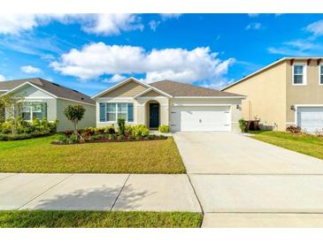 Charming single-story home with a well-manicured lawn, driveway, and attached two-car garage at 527 Noble Ave, Davenport, FL 33837